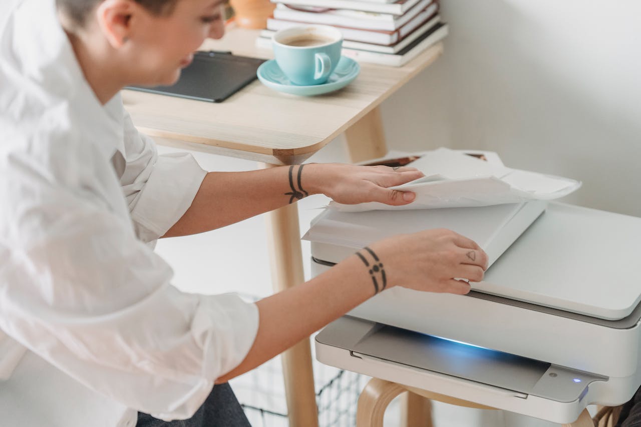 The Art of Drawing Readers In: Your attractive post title goes here From above of crop female worker taking sheets of paper for laser printing during remote work